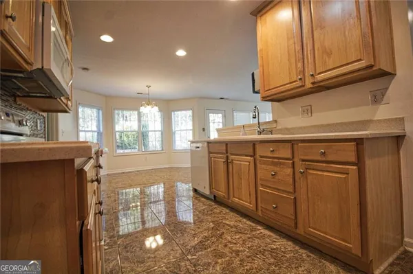 a kitchen with stainless steel appliances granite countertop a stove a sink and a microwave