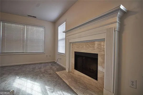a view of an empty room with a fireplace and a window