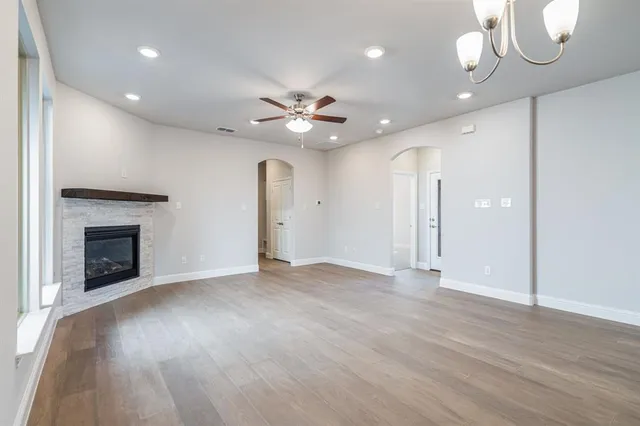 an empty room with fan and a fireplace