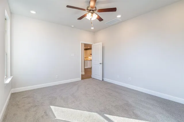 an empty room with closet and a chandelier fan