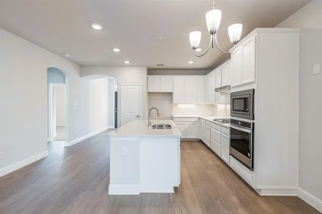 a kitchen with stainless steel appliances granite countertop a sink a stove and a refrigerator