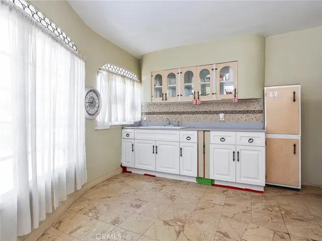 a kitchen with granite countertop a refrigerator and a sink