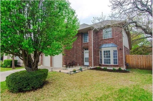 a view of a brick house with a large windows and a large tree
