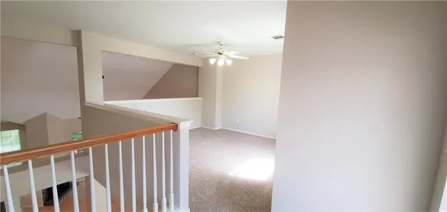 a view of a hallway with a chandelier fan