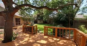 a view of a chair and tables under the trees