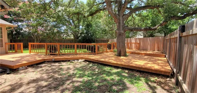a view of a yard with wooden fence