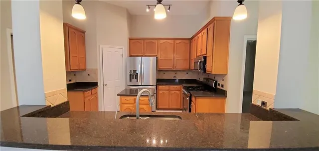 a kitchen with stainless steel appliances refrigerator dining table and chairs