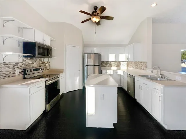 a kitchen with a sink stainless steel appliances and white cabinets
