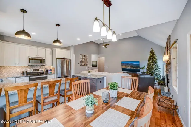 a large kitchen with a table chairs refrigerator and microwave