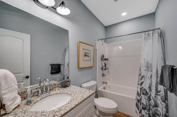 a bathroom with a granite countertop sink a mirror and a toilet