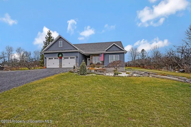 a front view of a house with yard and green space