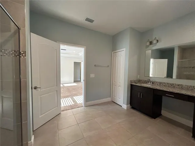 a large bathroom with a granite countertop tub sink shower and mirror