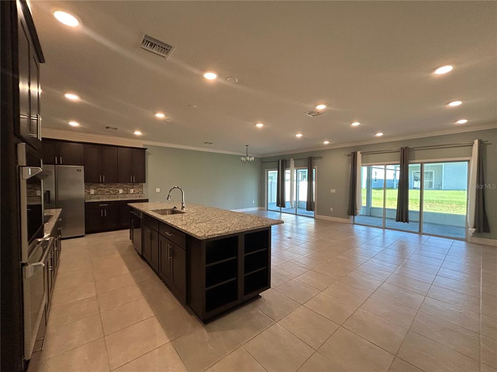 24470 Northwest 6th Road Newberry, FL 32669 - Photo 5 of 22 a large kitchen with stainless steel appliances a large counter top and a stove top oven