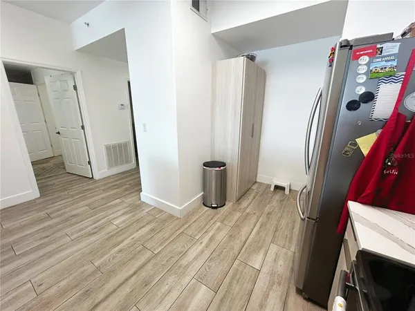 a kitchen with granite countertop a refrigerator and a stove top oven