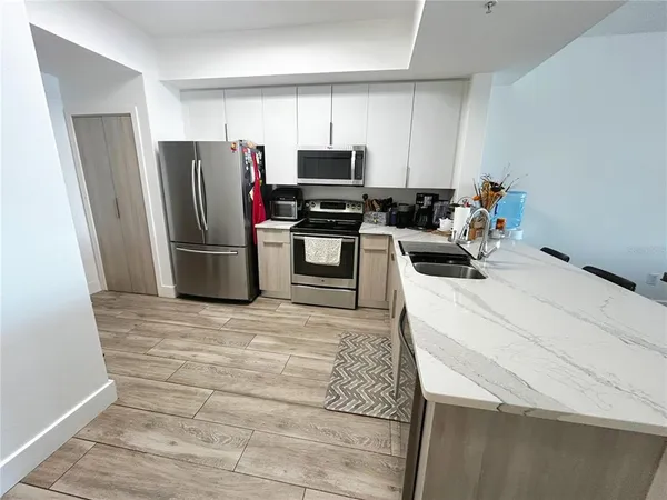 a kitchen with a sink stainless steel appliances and white cabinets