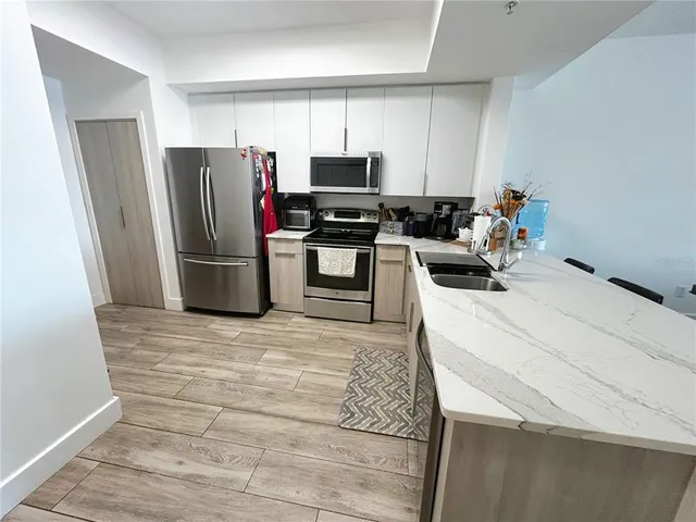 a kitchen with a sink stainless steel appliances and white cabinets