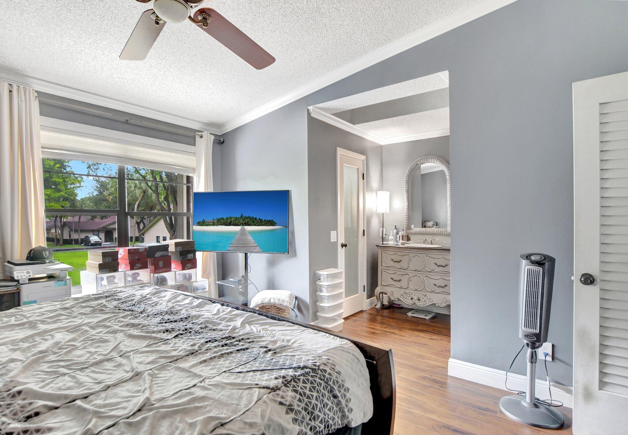 23398 Southwest 54th Way, Unit A Boca Raton, FL 33433 - Photo 18 of 29 a bedroom with a bed and large windows
