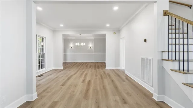 a view of staircase with lots of frames on wall and wooden floor