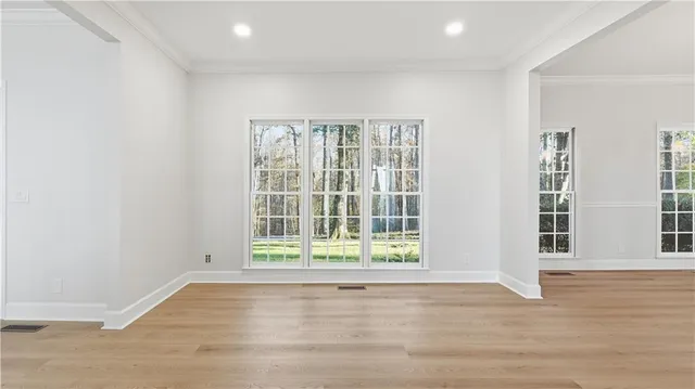 an empty room with windows a fireplace a ceiling fan and wooden floor