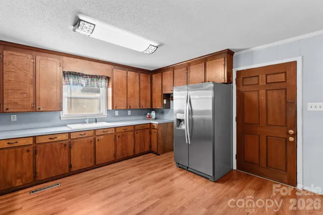 a kitchen with stainless steel appliances granite countertop a refrigerator a sink and dishwasher