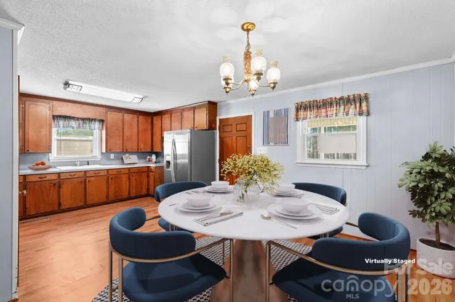 a view of a dining room with furniture a chandelier and wooden floor