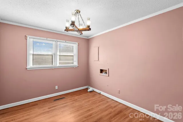 an empty room with wooden floor closet and chandelier fan