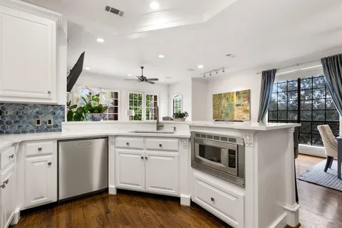 a kitchen with granite countertop white cabinets and white appliances