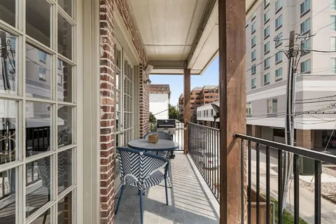 a view of a balcony with chairs and wooden floor