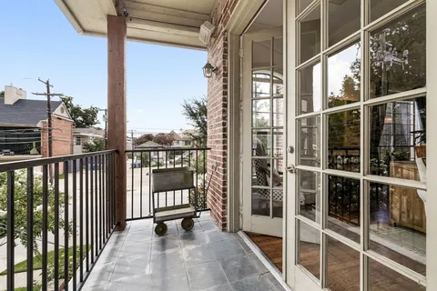 a view of a balcony with a floor to ceiling window with wooden floor
