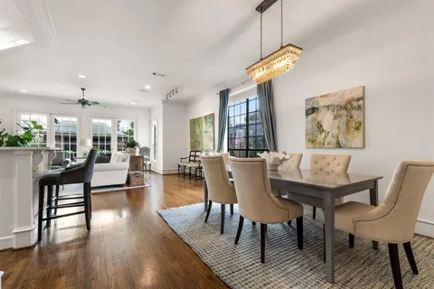a view of a dining room with furniture a chandelier and wooden floor