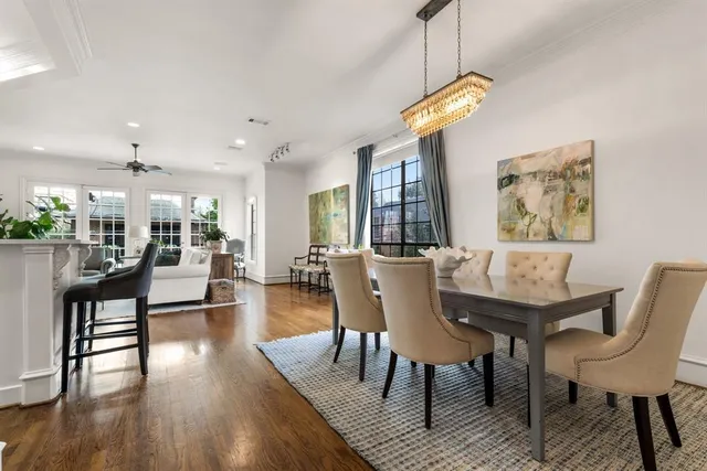 a view of a dining room with furniture a chandelier and wooden floor