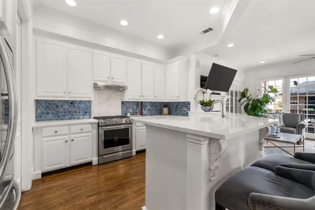 a kitchen with white cabinets and stainless steel appliances