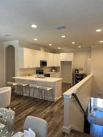 a large white kitchen with lots of counter space a sink and appliances