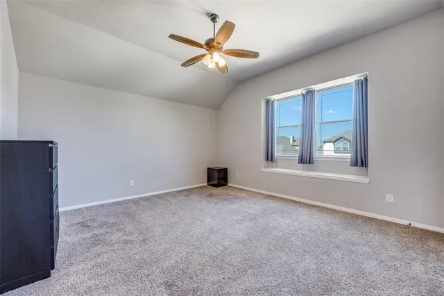 an empty room with windows and ceiling fan