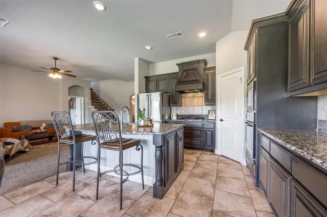 a kitchen with kitchen island granite countertop lots of counter top space and stainless steel appliances