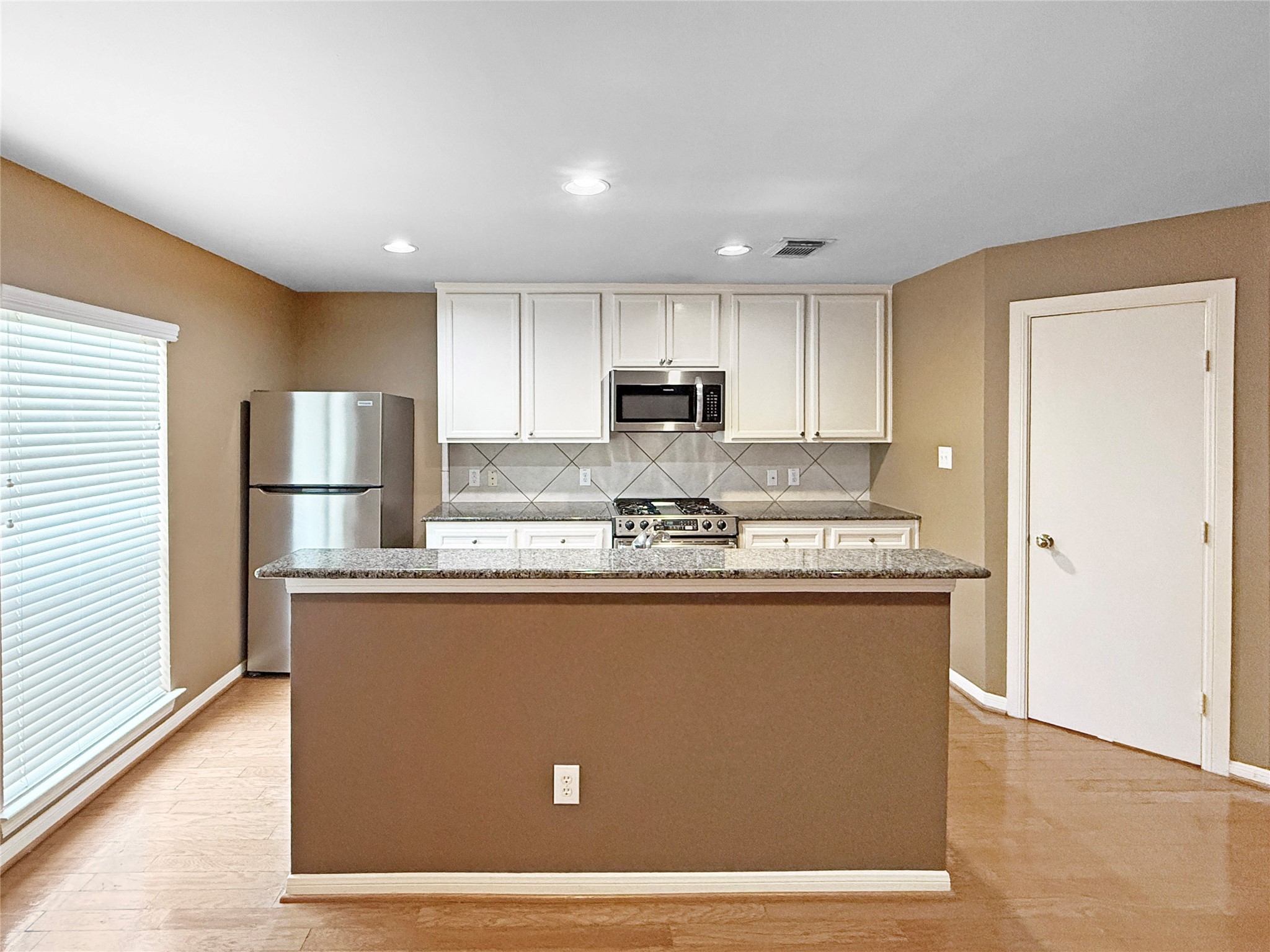 1263 West 17th Street Houston, TX 77008 - Photo 3 of 17 a view of kitchen with stainless steel appliances granite countertop refrigerator stove top oven and cabinets