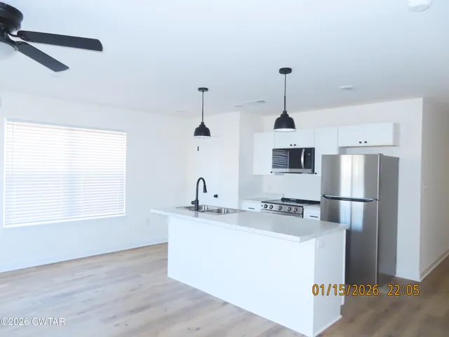 a view of a room with a ceiling fan and wooden floor