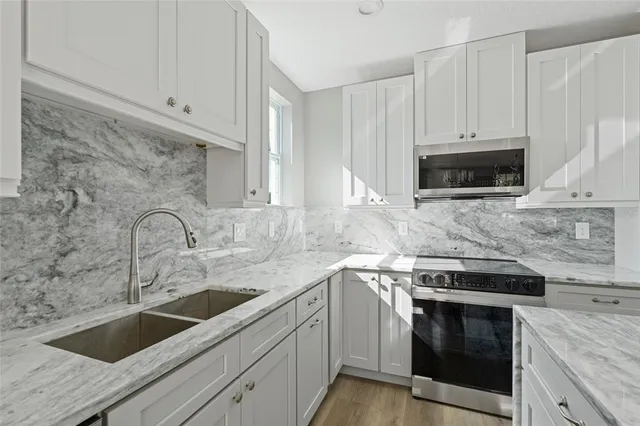 a kitchen with appliances a sink and cabinets