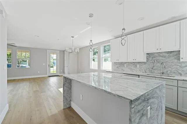 a kitchen with granite countertop a sink a stove cabinets and wooden floor