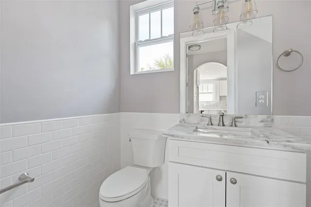 a bathroom with a granite countertop toilet sink and mirror