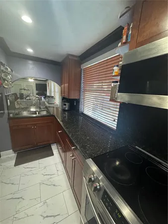 a kitchen with a sink window and cabinets