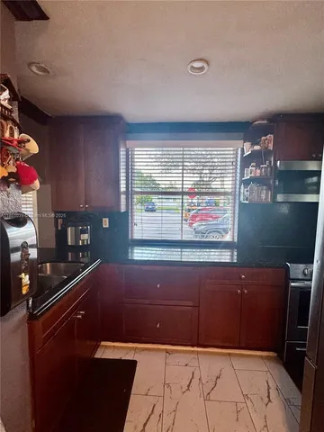 a kitchen with a sink window and cabinets