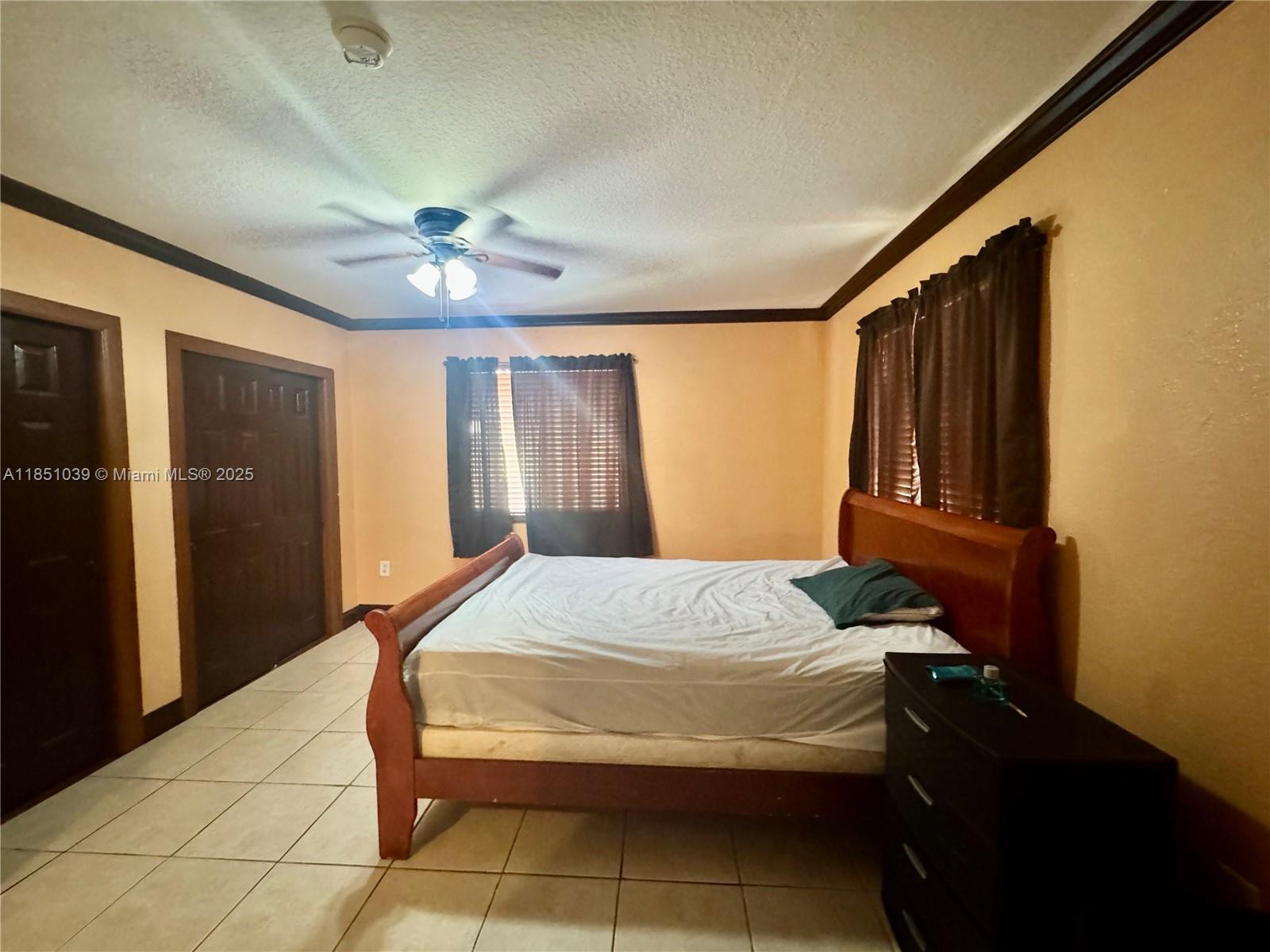 19550 Southwest 103rd Court, Unit 5 Cutler Bay, FL 33157 - Photo 22 of 28 a bedroom with a bed and a chandelier