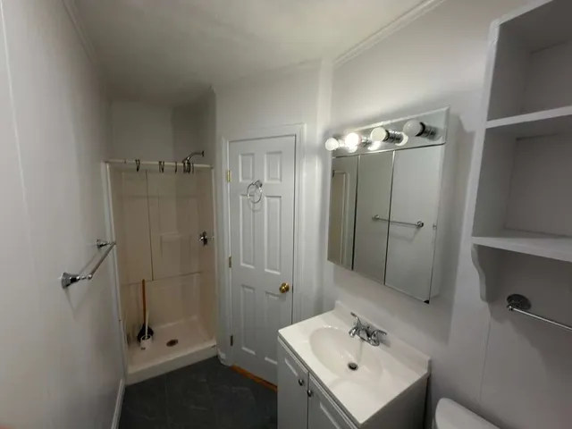 a bathroom with a shower sink and mirror