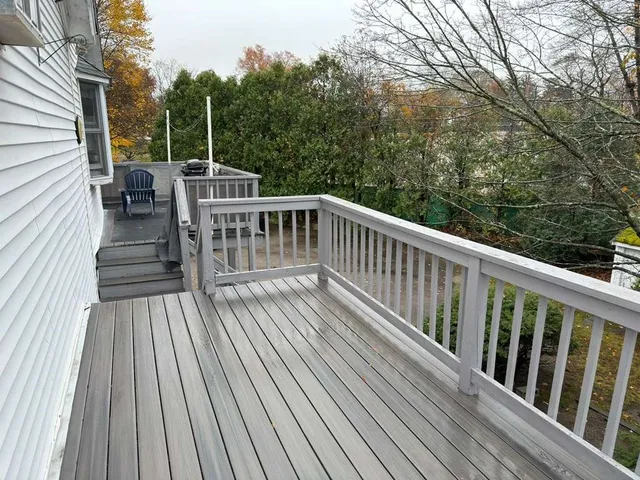 a view of balcony with wooden floor and fence
