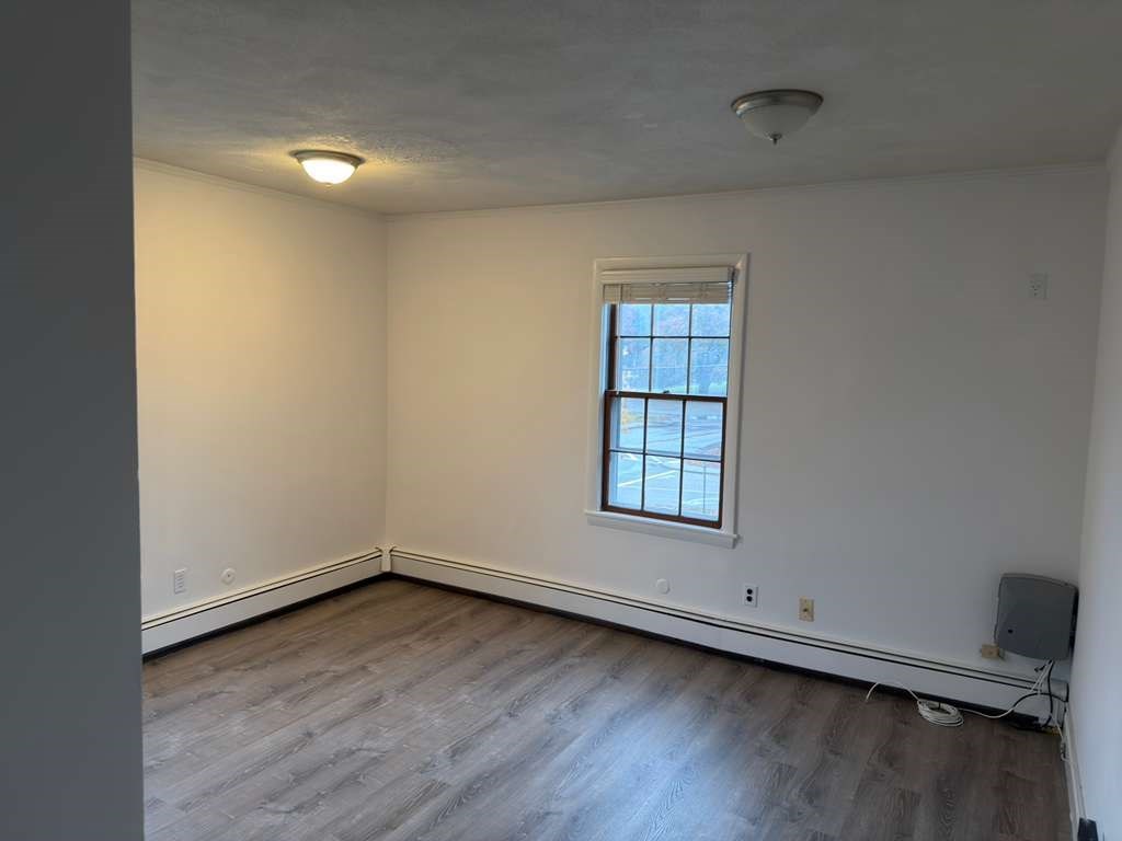 37 Exchange Street, Unit 37 Millis, MA 02054 - Photo 3 of 15 an empty room with wooden floor and windows