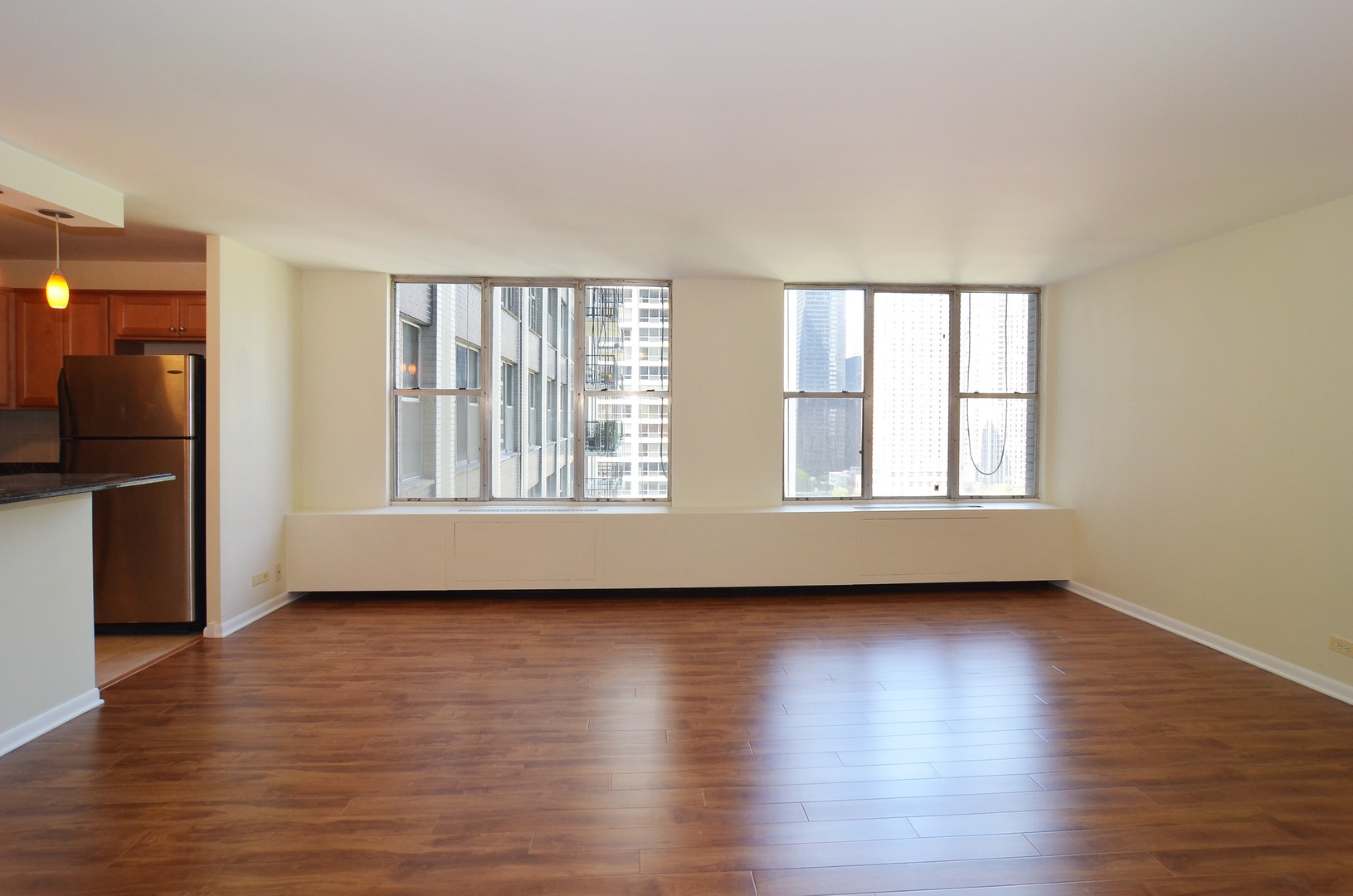 400 East Randolph Street, Unit 2222 Chicago, IL 60601 - Photo 3 of 18 an empty room with wooden floor and windows