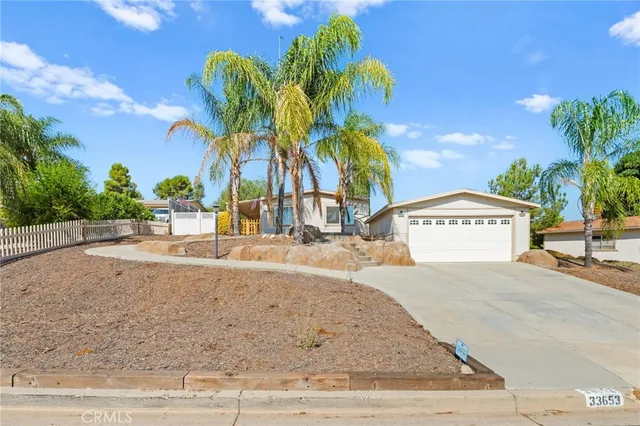 a view of a house with a yard and palm trees