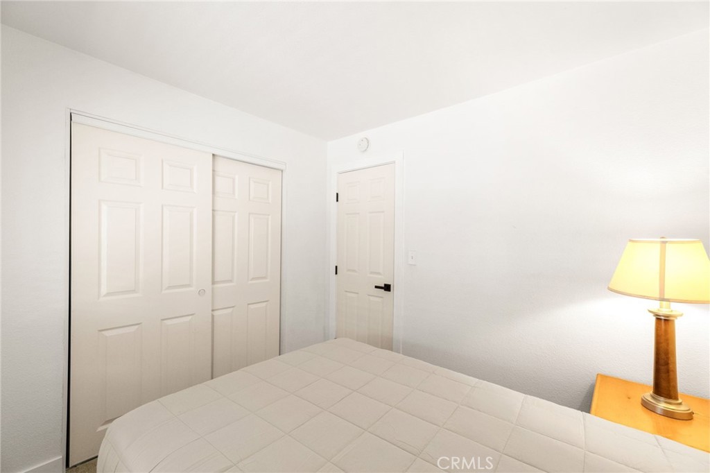 33653 Windmill Road Wildomar, CA 92595 - Photo 36 of 66 a bedroom with a bed and a lamp on table