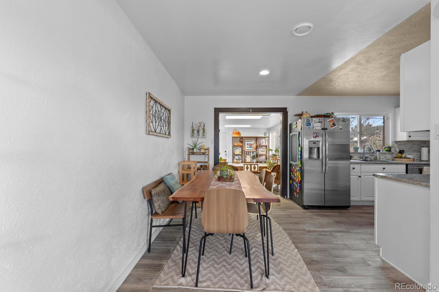 3106 South Wolff Street Denver, CO 80236 - Photo 11 of 48 a view of a dining room with furniture and a kitchen